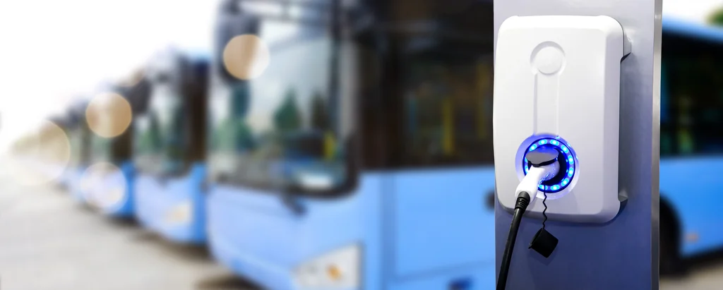Electric bus blurred behind an electric vehicle charger